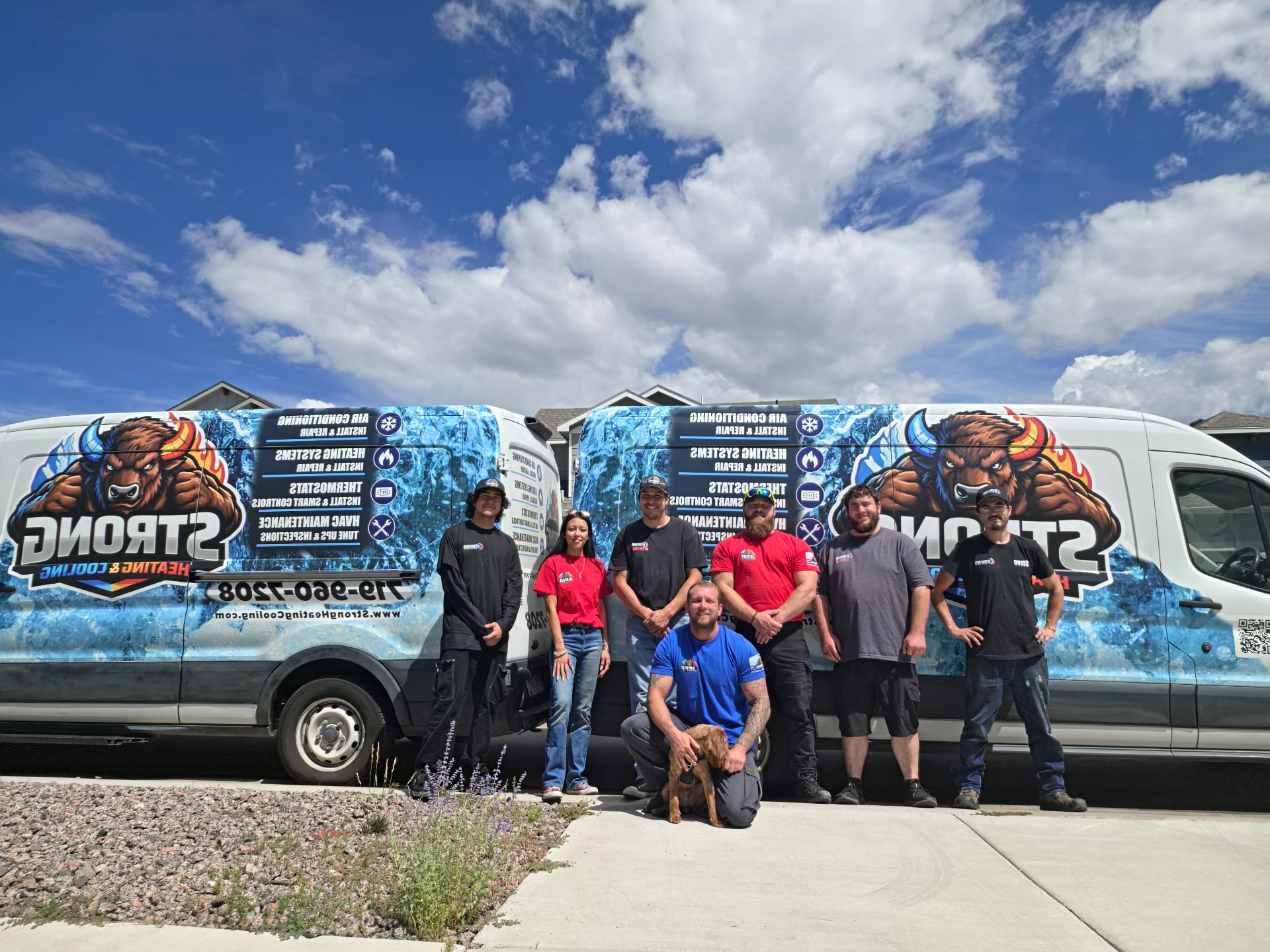 The Strong Heating And Cooling team standing in front of their wrapped service vans in Colorado Springs